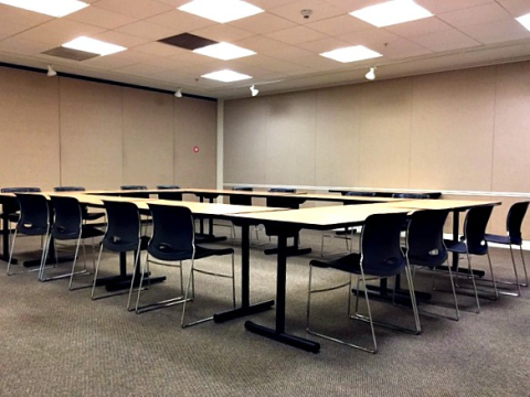 meeting room showing tables configured in a square. Tables are shown tucked into the tables