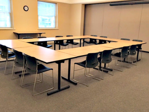 meeting room with tables shown in a square configuration, tables are shown tucked into tables