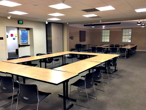 meeting room space showing tables and chairs. There are two square configurations of tables shown in the photo.