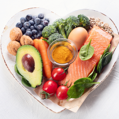 Heart-shaped plate full of vegetables and salmon